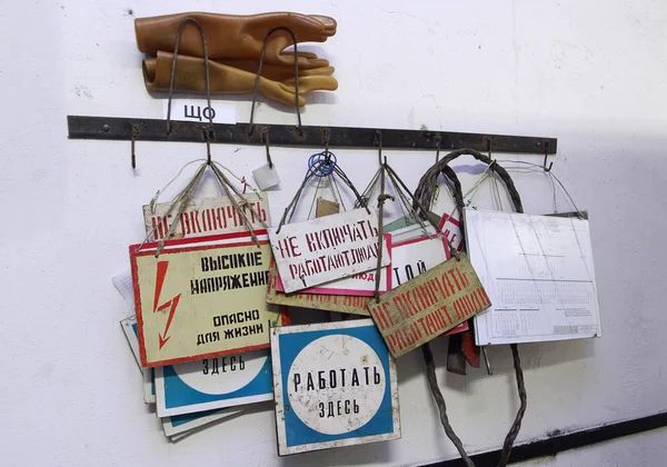 Många ryska industriell varningsskyltar i elektriska är hängande vägg. — Stockfoto