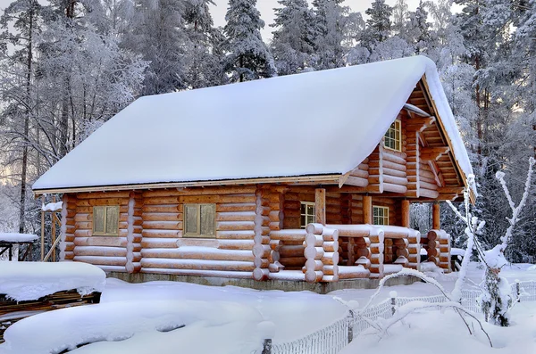 Nieuwe houten Russische sauna in een besneeuwde winter forest, zonnige dag. — Stockfoto