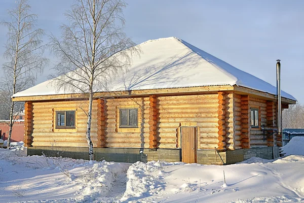 Wooden Country small house of timber stained yellow, snowy winter, sunny day. — Stock Photo, Image