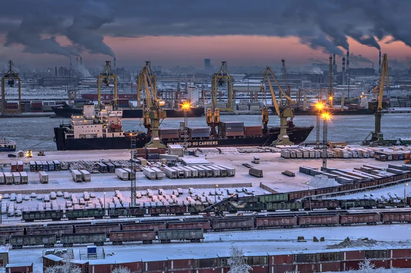 Lossen van vrachtschip in zee haven van winteravond. — Stockfoto