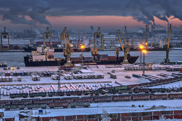 Unloading of cargo ship in sea port winter evening.