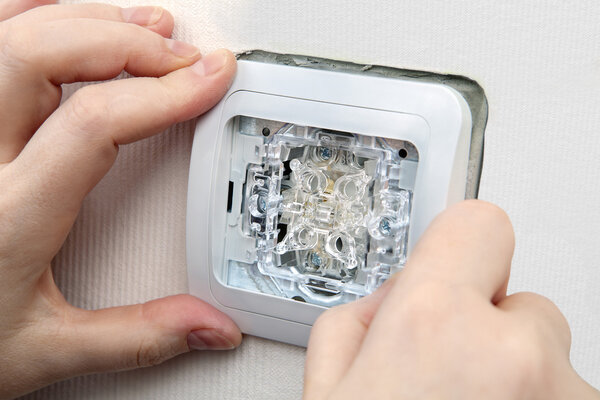 Close-up mount electric light switch  into wall box.