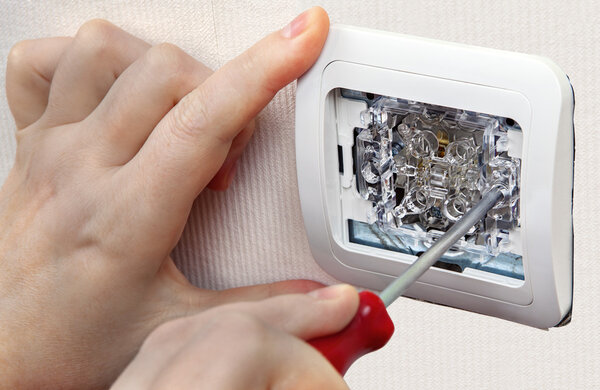 Mount wall light switch, close-up of human hand with screwdriver