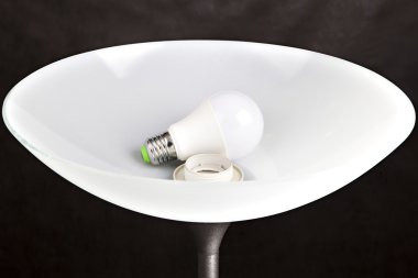 Energy-saving LED light bulb is in the lampshade Floor lamp. clipart