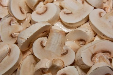 Kabaca doğranmış şampiyon mantarları. Yemek arkaplanı. Çiğ yenebilir mantarlar kapanıyor..