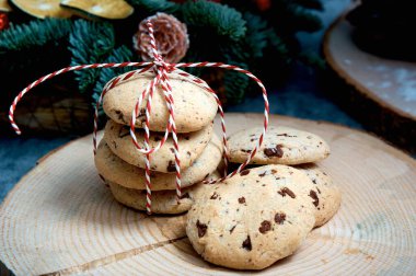 Çikolatalı yulaflı kek. Kırmızı-beyaz kabloyla bağlanmış bir yığın karaciğer bir Noel ağacının arka planına bağlı.