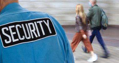 Güvenlik temsilcisi yayaları sokakta izliyor