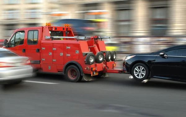 Motion blur, car tow truck rides on a city street