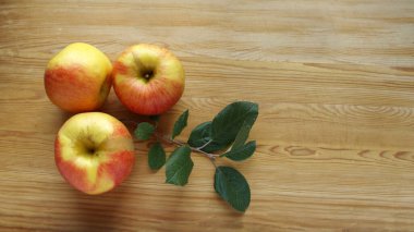 Ahşap yüzeyde meyveler ve elma yaprakları