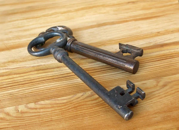 Two vintage keys on wooden background