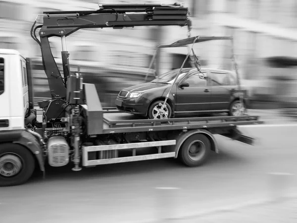 Motion blur, car tow truck rides on a city street