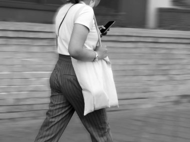 Hareket bulanıklığı gücü, çantalı ve cep telefonlu bir kadın 