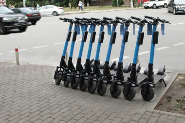 Kiralık elektrikli scooter 'lar kaldırımda duruyor. 