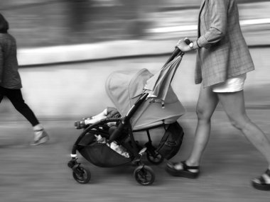 İnsanlar hareket halinde, bebek arabalı bir kadın.