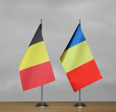 Belçika ve Romanya 'nın masa üstü bayrakları gri arka planda duruyor