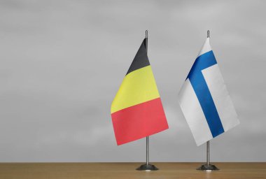 Belçika ve Finlandiya 'nın masa üstü bayrakları gri arka planda duruyor