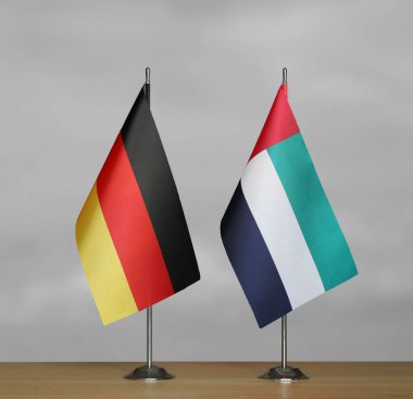 Almanya ve Emirliklerin bayrakları gri arka planda duruyor