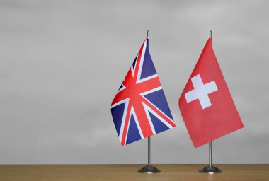 Gri arkaplanda Birleşik Krallık ve İsviçre bayrakları