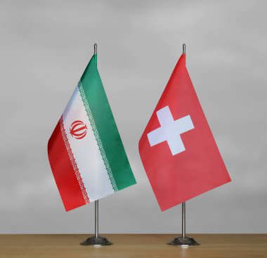 İran ve İsviçre 'nin bayrakları gri arka planda duruyor