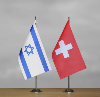 İsrail ve İsviçre 'nin bayrakları gri arka planda duruyor
