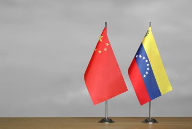 Çin ve Venezuela 'nın bayrakları gri arka planda duruyor.