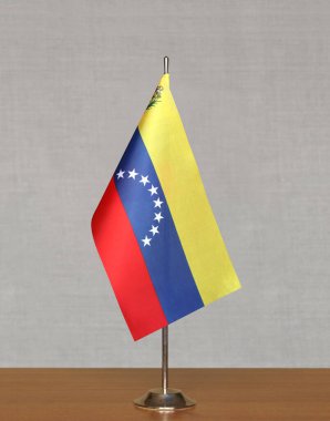 Bulanık gri bir arkaplanda duran Venezuela masa bayrağı