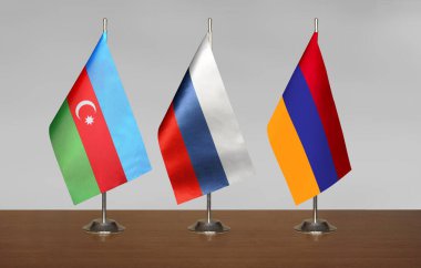 Masa bayrakları ve Azerbaycan, Rusya ve Ermenistan bayrağı bulanık gri bir arkaplanda duruyor