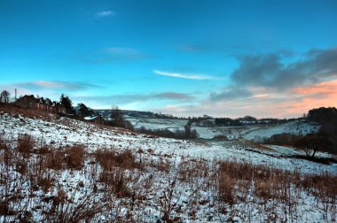 Batı Yorkshire Pennine bölgesindeki Hebden Köprüsü 'ndeki Hurst Lane' de bir dizi taş evlerle çevrili kar tarlaları.