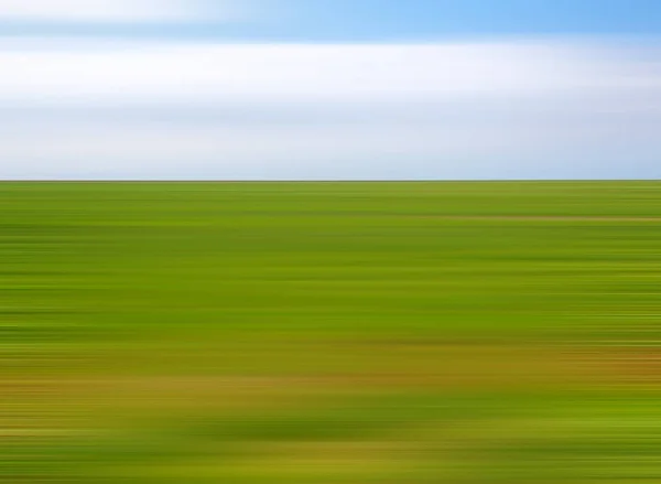 blurred modern minimalist abstract summer country landscape with green meadow grass and blue sky