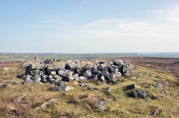 Calderdale, Batı Yorkshire 'da Midgley bozkırındaki değirmencilerin mezarı olarak bilinen Cairn' in tepesindeki çıplak taşlar.