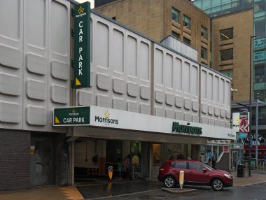 Leeds, Batı Yorkshire, Birleşik Krallık - 11 Mayıs 2021: Leeds 'deki Cookridge Caddesi' ndeki Merrion Center 'daki Morrison süpermarketinin girişindeki araç parkından ayrılıyor.