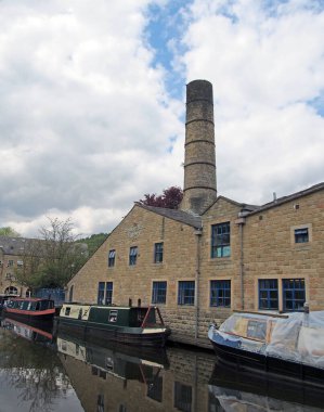 Hebden Köprüsü, Batı Yorkshire, Birleşik Krallık - 27 Mayıs 2021: Hebden Köprüsü 'ndeki Crossley Mill dışında Rochdale kanalı boyunca demirlemiş yüzen evler,