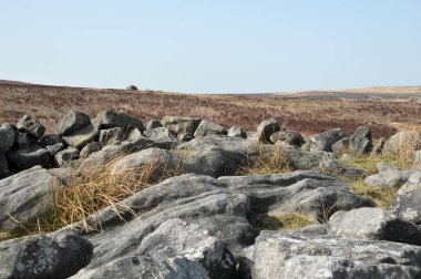 Calderdale, Batı Yorkshire 'daki Midgley bataklığında yer alan değirmencilerin mezarı olarak bilinen Cairn' in tepesindeki taşları ortaya çıkardı.