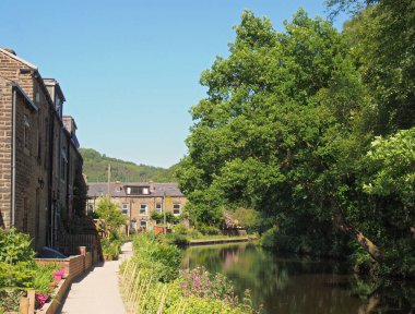 Batı Yorkshire 'daki Hebden Köprüsü' nde Eastwood 'da bir sıra taş evle çevrili bir kanal.