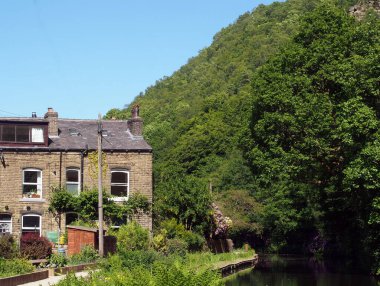 Batı Yorkshire 'daki Hebden Köprüsü' nde Eastwood 'da bir sıra taş evle çevrili bir kanal.