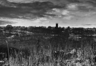 atmospheric image of snow and frozen grass in front of the village of heptonstall at twilight in heptonstall west yorkshire clipart