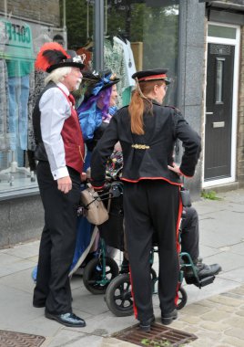 Hebden Köprüsü, Batı Yorkshire, Birleşik Krallık - 01 Ağustos 2021: Her yıl düzenlenen Hebden Köprüsü Steampunk haftasonunda kostümlü bir grup insan caddede durdu