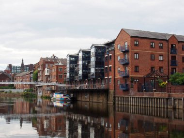 Leeds, Batı Yorkshire, Birleşik Krallık - 7 Temmuz 2021: Leeds 'e iniş çağrıları için nehir kenarındaki apartman ve barlar