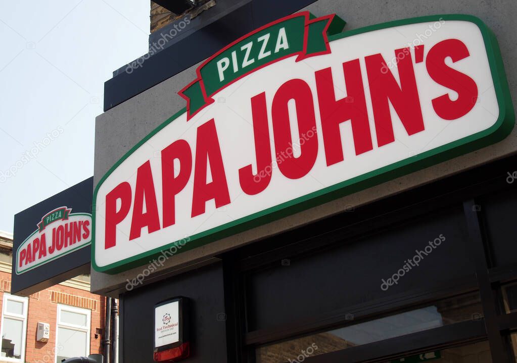 Brighouse, west yorkshire, united kingdom - 21 july 2021: sign above a papa johns pizza takeaway branch in brighouse west yorkshire