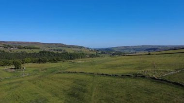 Açık mavi gökyüzünün altında uçsuz bucaksız yeşil bir manzara