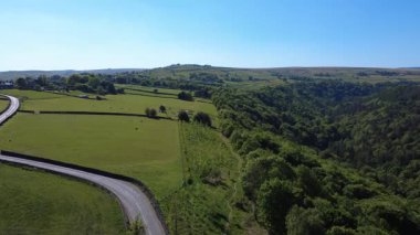 Hebden Köprüsü yakınlarındaki Draper Yolu 'nun ve Heptonstall' ın havadan görünüşü yazın Calderdale 'de otlayan koyunları ve uzaktaki Slack köyünü gösteriyor.