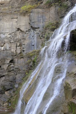 Şelale kayalık kayalıklardan aşağı dökülüyor.