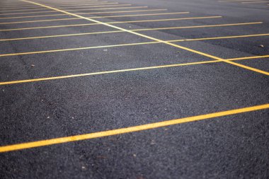 Asfalt yüzeyinde sarı çizgiler olan park yeri işaretleri