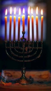 Dokuz mum, inancı ve geleneği sembolize eden, karanlık bir şenlik arka planında yanar. Şenlikli atmosfer, Hanuka kutlamalarının ve ayinlerin özünü yansıtıyor..