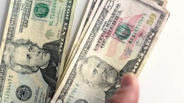 Birkaç dolarlık banknotları tutan el sıkışıyor.