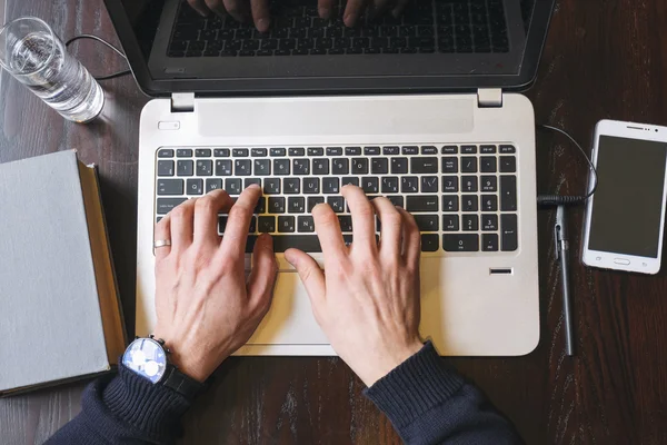 Uitzicht op mans handen typen op laptop op werkplek — Stockfoto