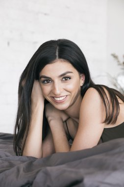 Mutlu kız kameraya bedcloth üzerinde