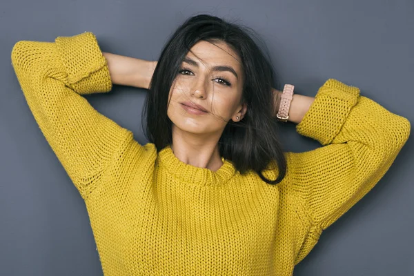 Modelo relaxado sorrindo para a câmera com cabelo ventoso — Fotografia de Stock