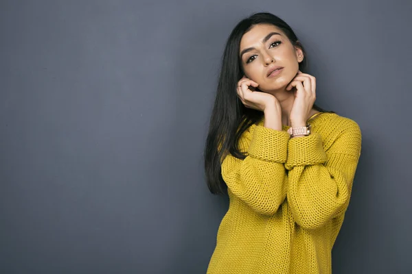Armenian girl with arms near face in yellow sweater — Stock Photo, Image