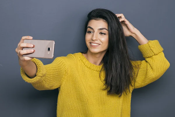 Portrait of beautiful girl making selfie against of wall — Stock Photo, Image